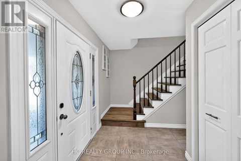 A hallway with white doors and a wooden staircase.