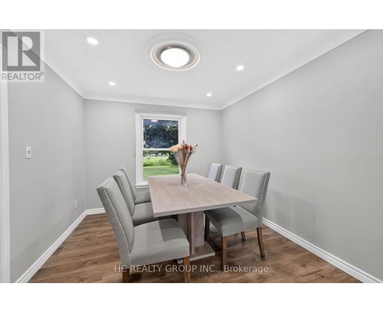 A dining room with a table and chairs.