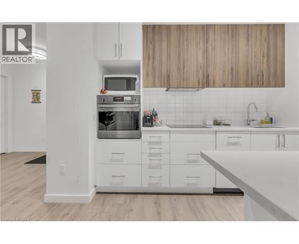 A modern kitchen with white cabinets and a wooden backsplash.