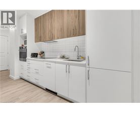 A modern kitchen with white cabinets and a wooden overhead.