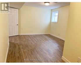 A room with wooden flooring and a white door.