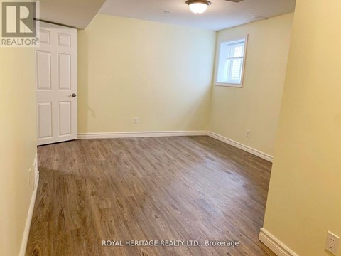 A room with wooden flooring and a white door.