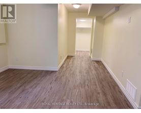A hallway with wood flooring and white walls.