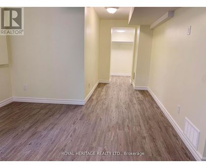 A hallway with wood flooring and white walls.