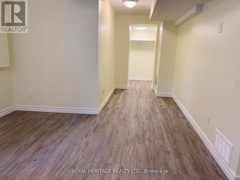 A hallway with wood flooring and white walls.