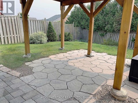 A patio with a stone walkway and wooden pillars.