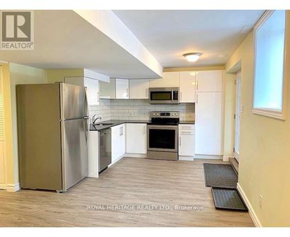 A kitchen with a refrigerator, microwave, oven, and stove.