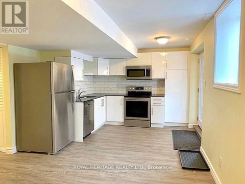A kitchen with a refrigerator, microwave, oven, and stove.