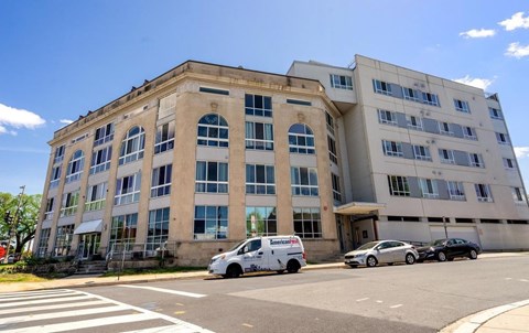 A white van is parked in front of a building.