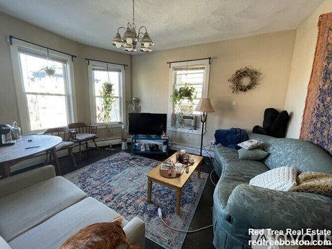 A living room with a couch, a coffee table, and a television.