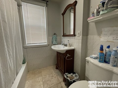 A bathroom with a sink, mirror, and toiletries.