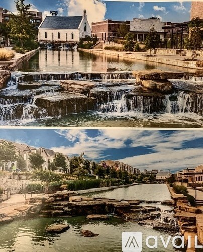 A waterfall in a park with a building in the background.