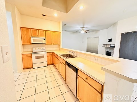 A kitchen with wooden cabinets and white appliances.