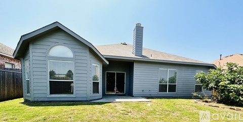 A house with a grey exterior and a white roof is for sale.