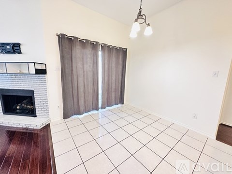 A living room with a fireplace and a tiled floor.
