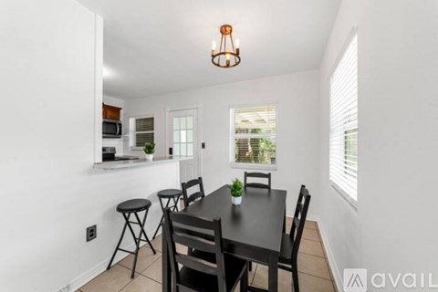A dining area with a black table and chairs.