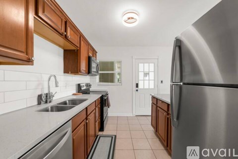 A kitchen with brown cabinets and a stainless steel refrigerator.
