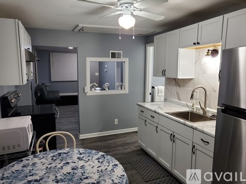 A kitchen with a table and chairs in the foreground and a refrigerator in the background.