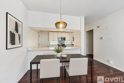 A dining room with a table and chairs and a framed picture on the wall.