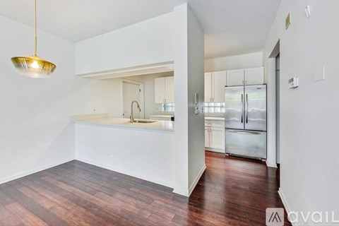 A kitchen with a white counter and a wooden floor.