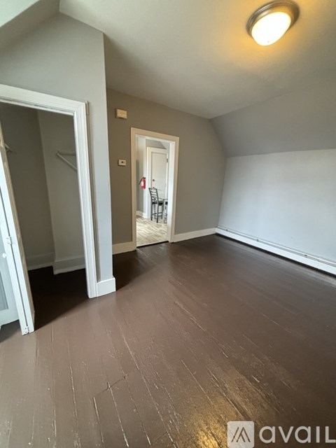 A room with wooden flooring and a white door.