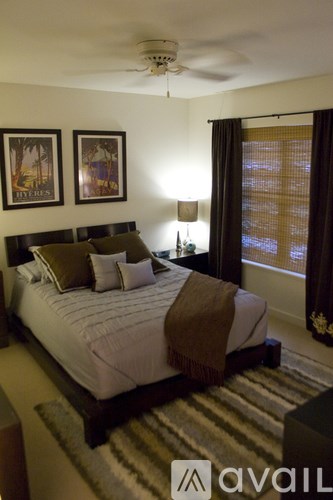 A bedroom with a large bed and two pictures on the wall.