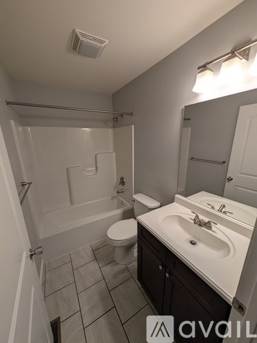 A bathroom with a toilet, sink, and bathtub.
