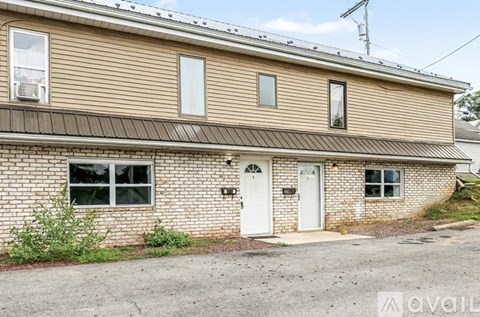 A house with a white door and windows is for sale.