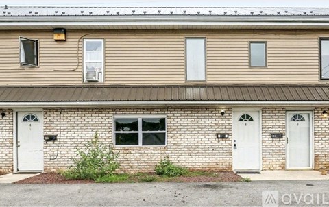 A building with a beige siding and white doors.