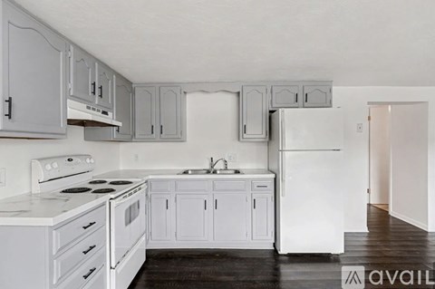 A kitchen with white appliances and cabinets.