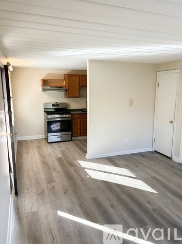 A kitchen with a refrigerator, oven, and cabinets.
