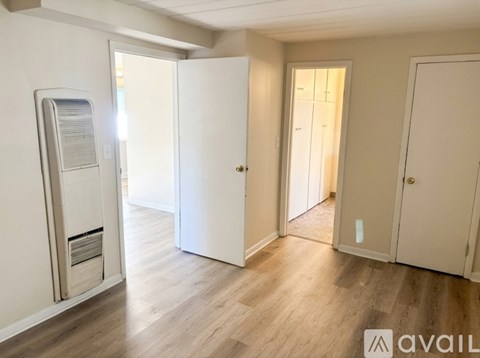 A room with a white door and a white cabinet with a drawer open.