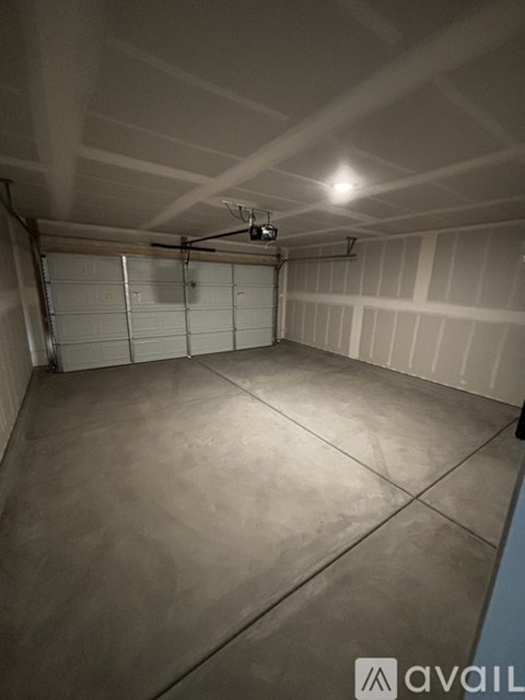 A spacious garage with a concrete floor and white walls.