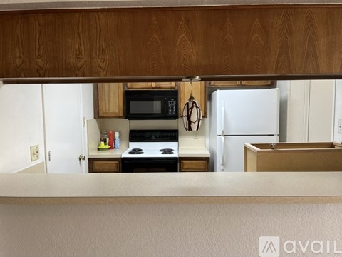 A kitchen with a white refrigerator and wooden cabinets.