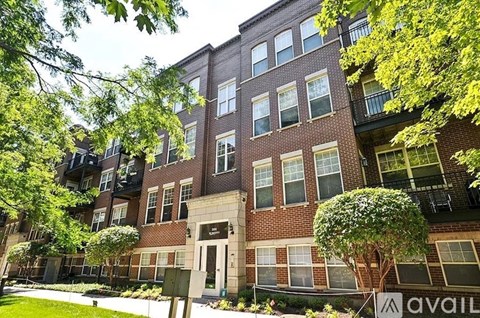A multi-story brick building with a green lawn in front.