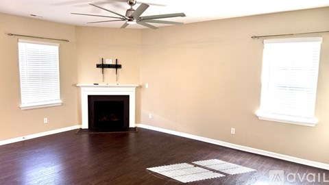 A living room with a fireplace and a fan.