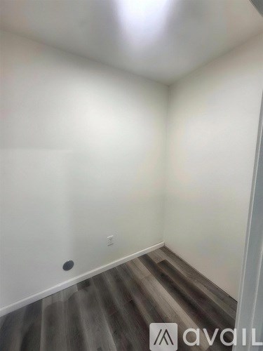A room with a wooden floor and white walls.
