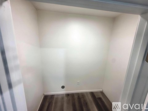A room with a wooden floor and white walls.