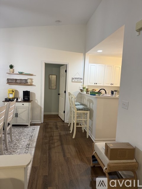 A kitchen with white cabinets and a wooden floor.