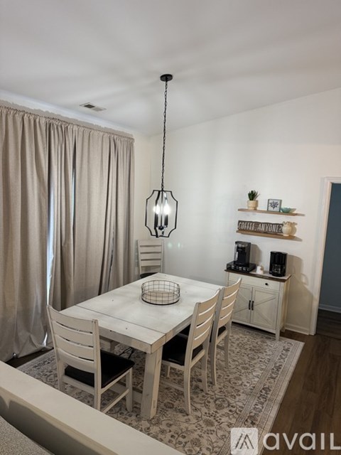 A dining room with a table and chairs.