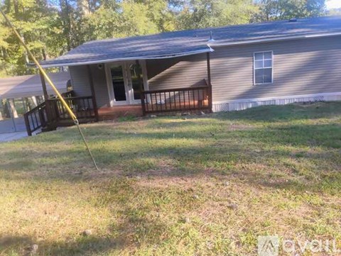 A house with a grey roof and a porch with a railing.
