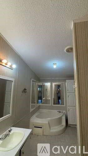 A bathroom with a bathtub, sink, and mirror.
