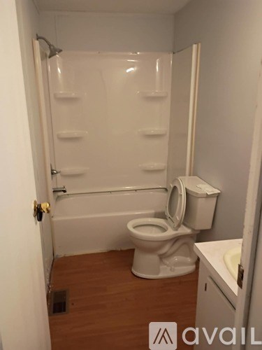 A small bathroom with a toilet, sink and shower.