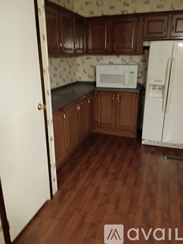 A kitchen with wooden cabinets and a white fridge.