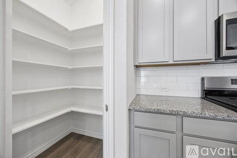 A kitchen with white cabinets and a granite countertop.