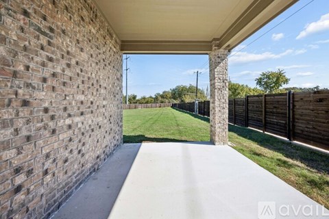 A covered walkway with a brick wall on one side and a wooden fence on the other.