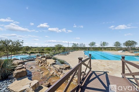 A pool surrounded by rocks and a wooden deck.