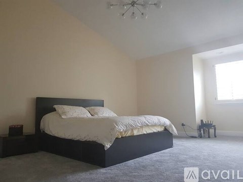 A bedroom with a large bed and a chandelier.