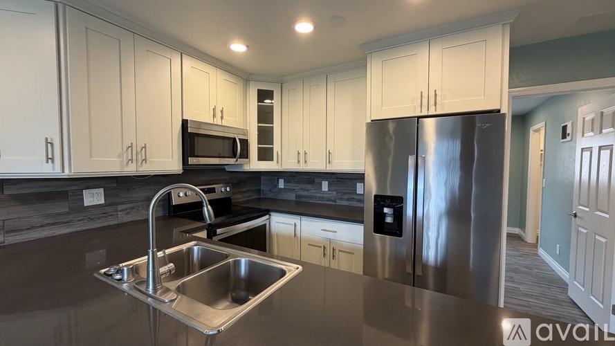 A kitchen with a sink and a refrigerator.