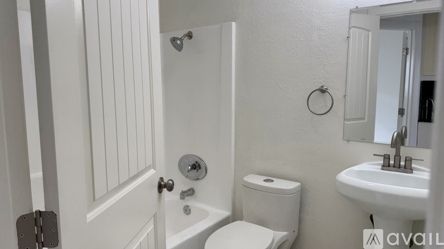 A white bathroom with a toilet, sink, and tub.